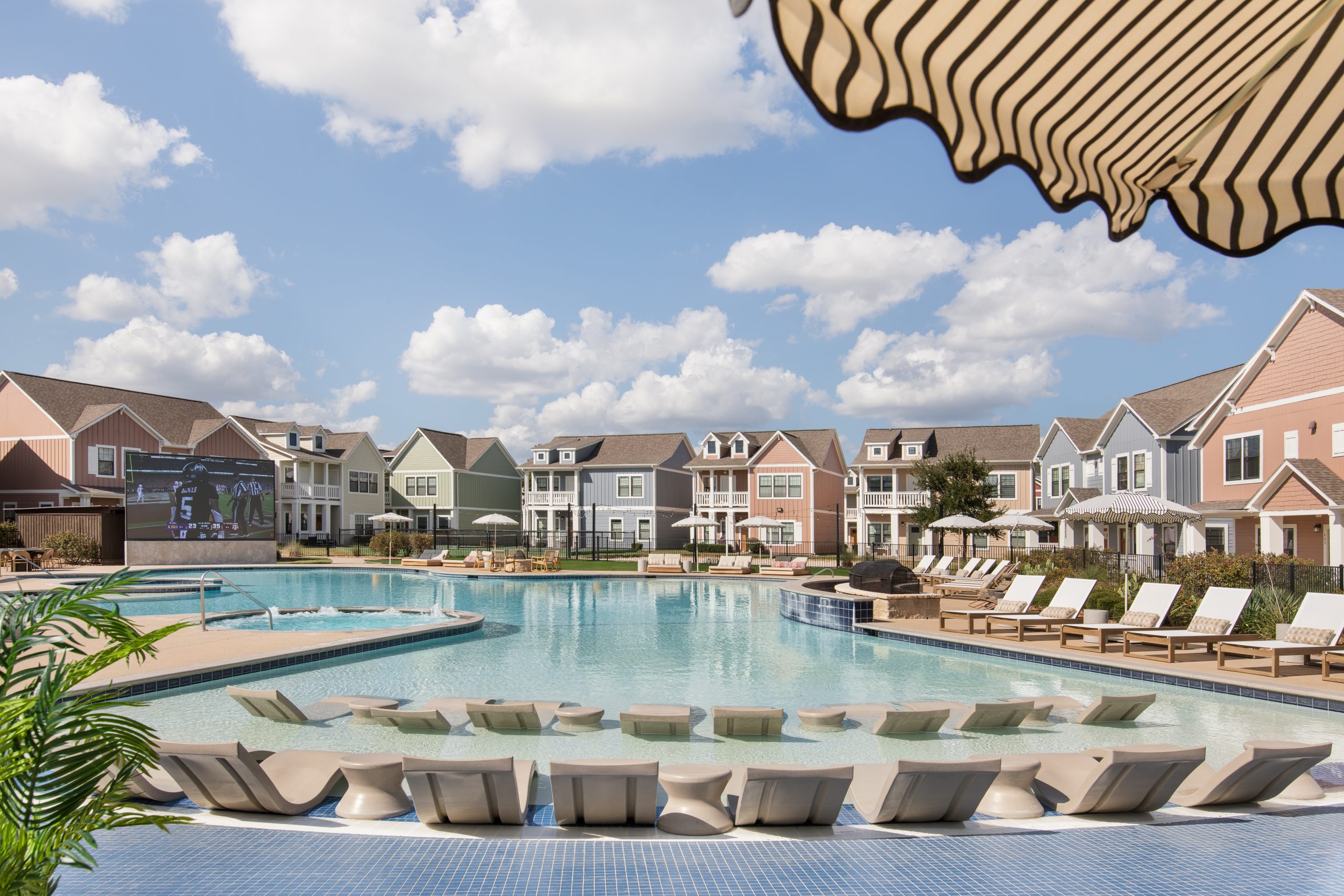 The Heights College Station cottage-style student housing buildings surrounding the community pool near Texas A&M University.