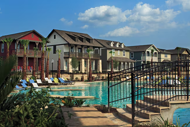 Resort-style pool with lounge chairs and cottage-style student homes at The Cottages of College Station.