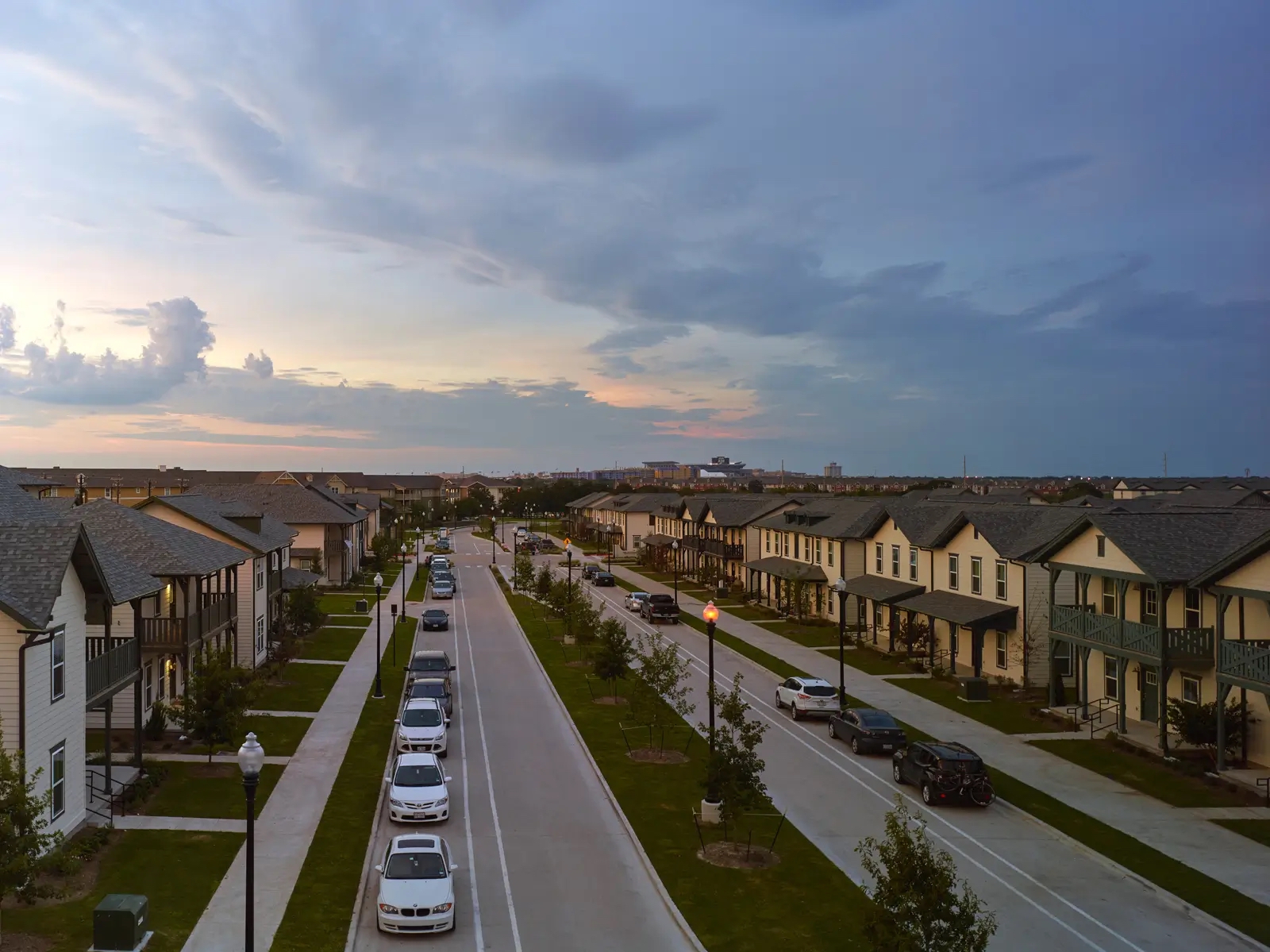 Neighborhood-style streetscape at The Junction at College Station featuring townhomes, sidewalks and resident parking.