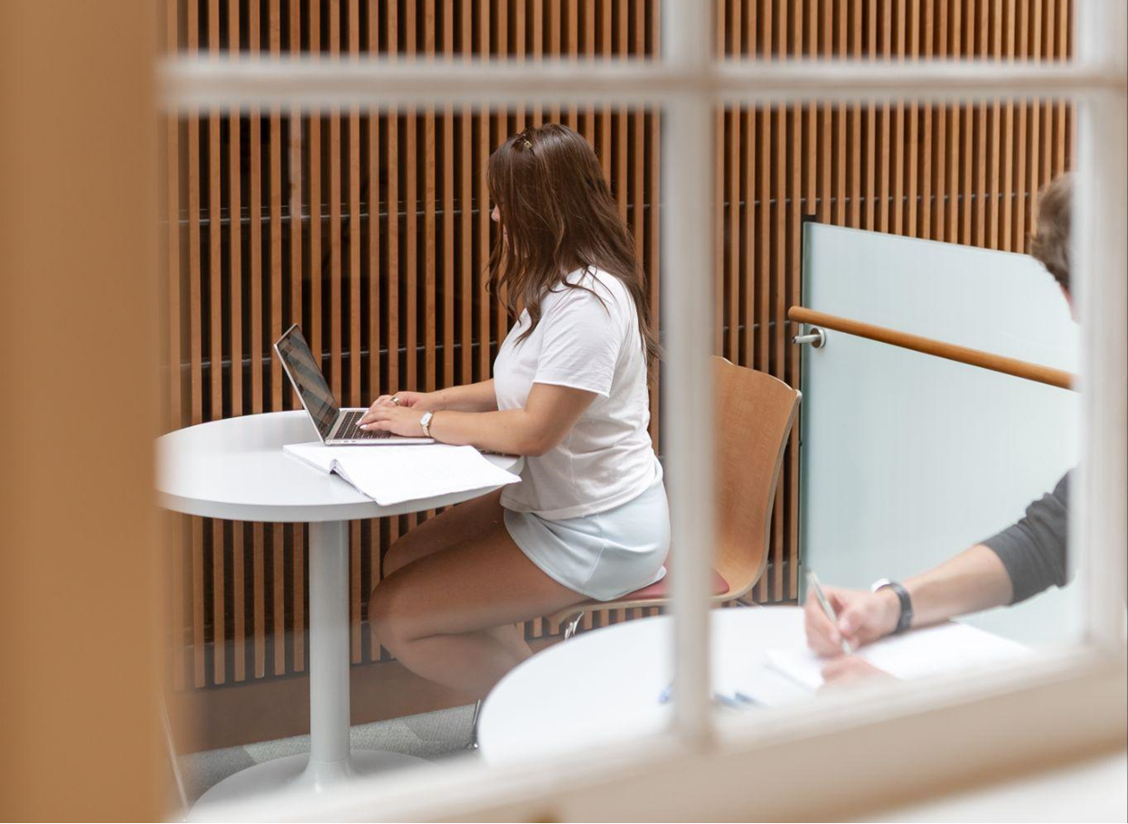 Student working on laptop near Texas A&M.